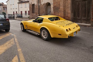 Klasik Amerikan spor arabası Cheevrolet Corvette C3 Stingray. 11 Kasım 2018 'de Bagnacavallo, RA, İtalya' da yapılan klasik bir araba rallisinde 70 'lerin yan boruları egzoz dumanlı.