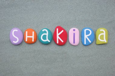 Shakira, kadın ismi yeşil kumların üzerine çok renkli taş harflerle yazılmış.