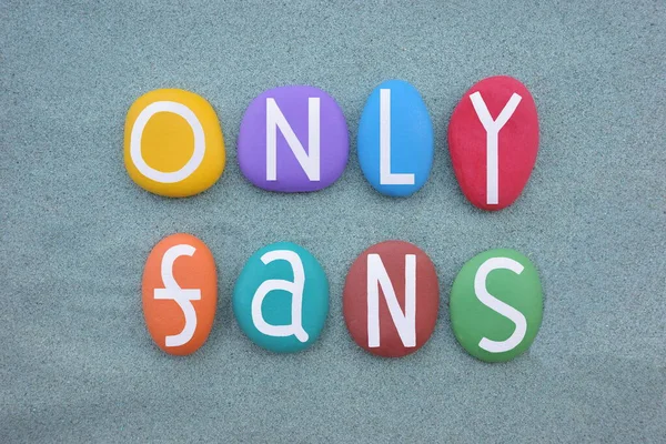 Only Fans, creative message composed with multi colored stone letters over green sand