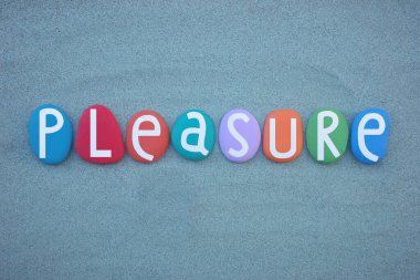Pleasure, creative word composed with hand painted multi colored stone letters over green sand clipart