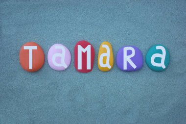 Tamara 'nın kutlaması, elle boyanmış çok renkli taş harflerle yazılan yeşil kumların üzerine verilmiş dişi ismi.