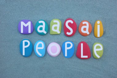 Masai halkı, kuzey, orta ve güney Kenya ve kuzey Tanzanya 'da yaşayan Nilotik etnik grup, Afrika Büyük Göller bölgesi yakınlarında, yeşil kum üzerinde çok renkli taş harflerle oluşturulmuş yaratıcı logo