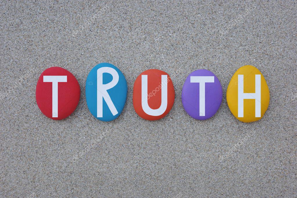 Truth, the quality or state of being true, creative text composed with hand painted multi colored stone letters over beach sand