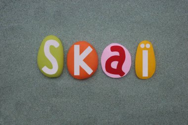 Skai, kadın ismi. Elle yazılmış. Yeşil kumların üzerine çok renkli taş harfler çizilmiş.