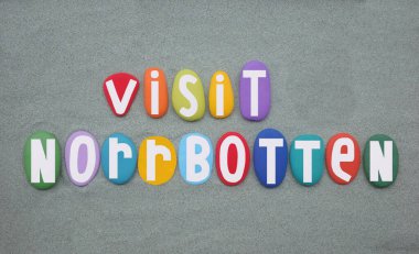 Visit Norrbotten, province of Sweden creative hand painted multi colored stone letters over green sand clipart