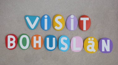 Bohuslan 'ı ziyaret et, Bohuslan, İsveç' in Gotaland eyaleti, kumsaldaki kumların üzerine çok renkli taş harflerle yazılmış bir hatıra.