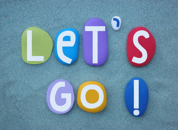 Пойдем, мотивационная фраза, выражающая волнение, мотивацию и энтузиазм, захватывающая сущность приключений и действий, творческий текст, составленный из разноцветных рукописных каменных букв на зеленом песке