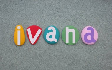 Ivana, kadın ismi. Çok renkli el yazısıyla yeşil kumların üzerine taş harfler çizilmiş.