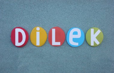 Dilek, Türkçe dilek, istek veya arzu anlamına gelen Türkçe, çok renkli el yazısıyla oluşturulmuş yaratıcı metin yeşil kum üzerine taş harfler