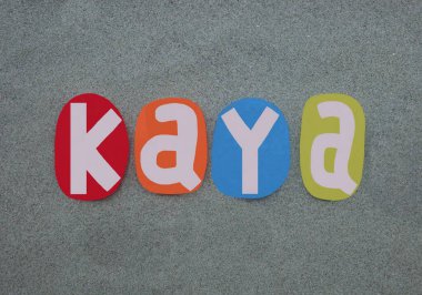 Kaya, kadın ismi. Çok renkli el yazısıyla yazılan yeşil kumların üzerine taş harfler çizilmiş.