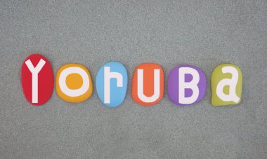 Yoruba, Niger-Congo language that is spoken in West Africa, primarily in Southwestern and Central Nigeria, Benin, and parts of Togo, creative logo composed with multi colored hand painted stone letters over green sand