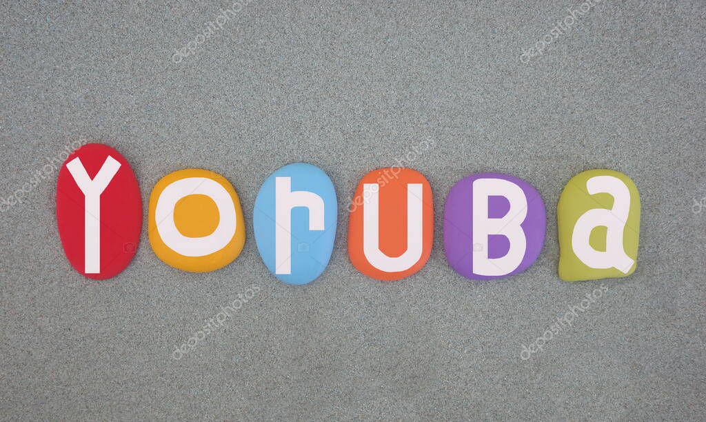 Yoruba, Niger-Congo language that is spoken in West Africa, primarily in Southwestern and Central Nigeria, Benin, and parts of Togo, creative logo composed with multi colored hand painted stone letters over green sand