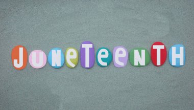 Birleşik Devletler 'de köleliğin sona ermesinin en eski ulusal anıtı olan Juneteenth, yeşil kumların üzerine çok renkli taş harflerle boyanmış.