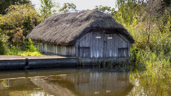 Norfolk kadınlarının üzerinde eski bir sazdan kayıkhane var. Hickling 'de, Norfolk' ta bir köy.