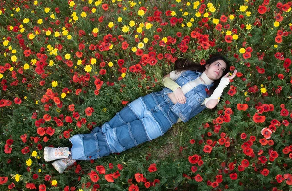 赤いケシの花の分野に眠っている若い幸せな女の子 春の女性のドローン航空 — ストック写真