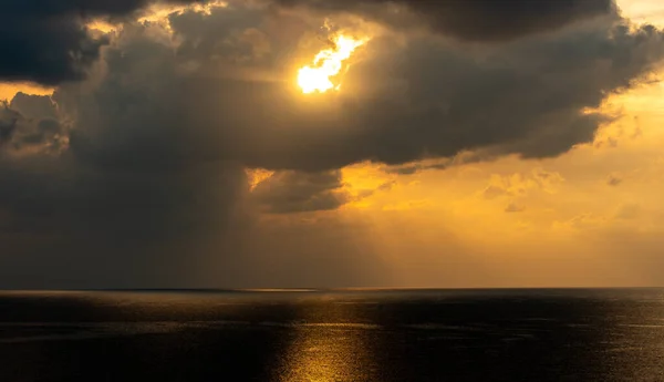 太阳升起在海面上 乌云密布 呈橙色 早上的海景 阳光照在海里 第一道光 — 图库照片