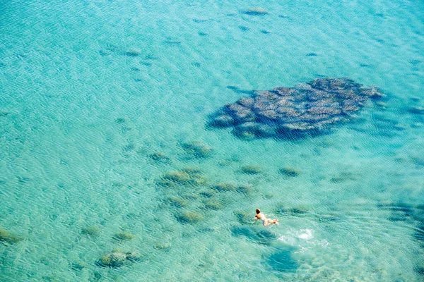 Unrecognized person floating and relaxing in the sea. Summer holidays. People swimming. Protaras Cyprus