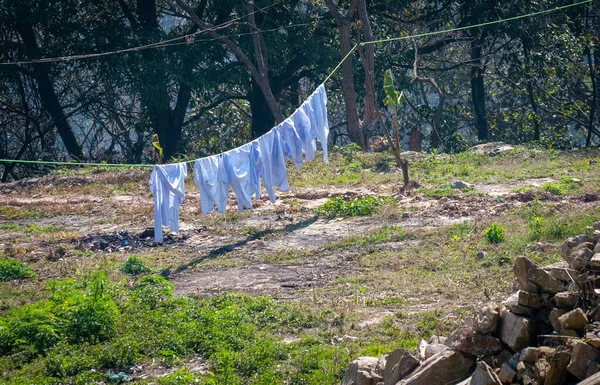 White hospital laundry hanging on a rope and drying outdoor in the clean air saving the environment.
