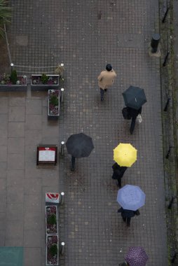 Yağmurda yürürken şemsiyesi olan bir grup tanınmamış insan. İş çıkışı, iş yerindeki insanlar. Londra İngiltere