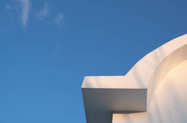 White curved roof of building against blue sky. Minimal architecture symmetry. Copy space for text