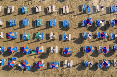 Drone aerial scene of beach umbrellas in a sandy coast. Summer holidays in the sea