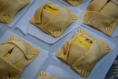 Traditional cypriot easter delicious cheese pastries ready to be cooked on a clay oven. Flaounes pies and are made with various cheese.
