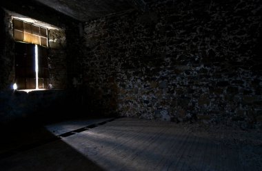 Empty abandoned creepy deserted empty room with bright sun lights entering the windows.