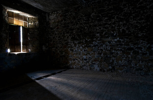 Empty abandoned creepy deserted empty room with bright sun lights entering the windows.