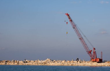 Crane machine building a water barier at a marina. Protaras Cyprus