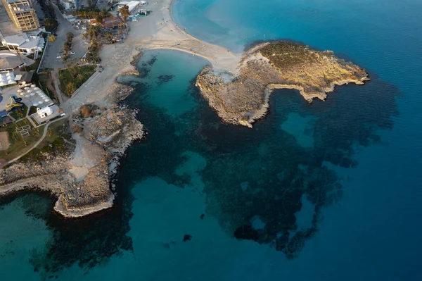 Kışın boş kumsalın sahil şeridine insansız hava aracı görüntüsü. Yaz tatili. Nissi plaj körfezi Ayia Napa, Kıbrıs