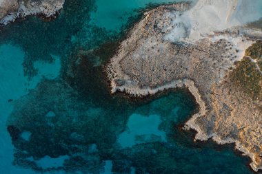 Kışın kayalık sahil adasının insansız hava aracı görüntüsü. Turkuaz mavi su, Nissi plaj körfezi Ayia Napa, Kıbrıs