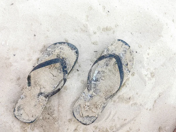 砂浜で夏の足のスリッパのペア リラックスして休暇 — ストック写真