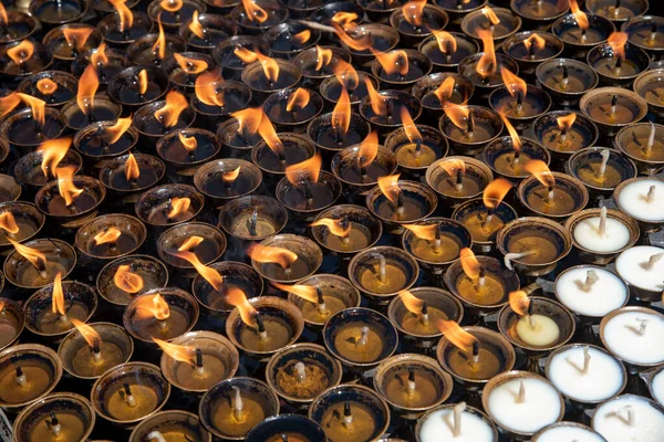 ヒンドゥ寺院のオレンジ色の炎で輝く油の宗教的なろうそくのグループ 信仰と宗教のシンボルと願いと祈り — ストック写真