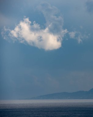 Deniz burnu, fırtınalı bir günde dağın tepesinde beyaz bulut. Paphos Kıbrıs