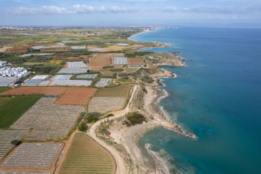 Arka arkaya seraların hava aracı görüntüsü, sebze ve meyve yetiştiren şeffaf bir film ile kaplı. Gıda ekimi, biyolojik ürünler. Kıbrıs Rum Kesimi