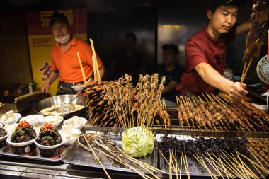 Pekin, Çin, Haziran 01: 2018: Pekin Çin 'deki çerez caddesinde geleneksel yemek pişiren Çinli aşçı. Lezzetli sokak fast food