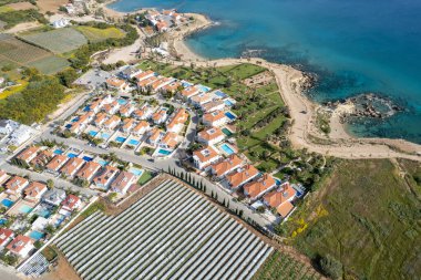 Huzurlu kayalık sahillerde lüks evleri olan bir tatil köyünün insansız hava aracı. Denizde yaz tatili. Kıbrıs Protaras