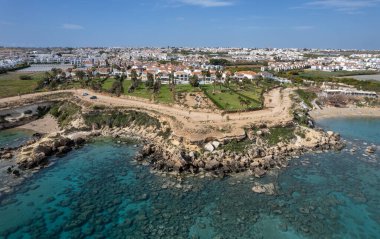Huzurlu kayalık sahillerde lüks evleri olan bir tatil köyünün insansız hava aracı. Denizde yaz tatili. Kıbrıs Protaras