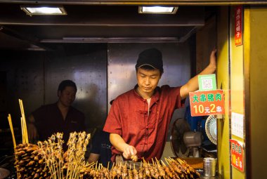 Pekin, Çin, Haziran 01: 2018: Pekin Çin 'deki çerez caddesinde geleneksel yemek pişiren Çinli aşçı. Lezzetli sokak fast food