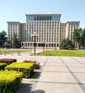 Pekin, Çin - Haziran 12018: Pekin 'deki ünlü ve prestijli Tsinghua Üniversitesi binasının ana girişinde bisiklete binen öğrenciler