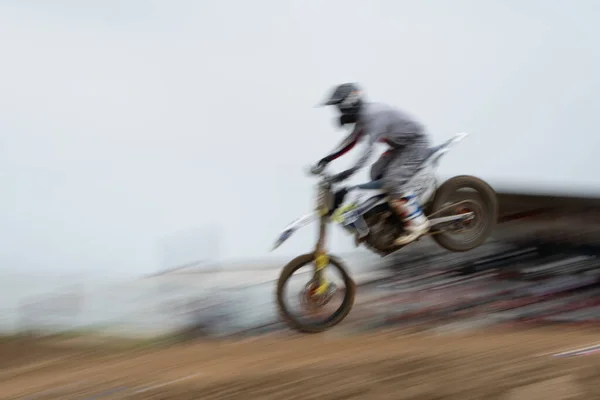 未被认可的运动员骑着摩托车在越野赛中跳上空中 速度慢极限运动 — 图库照片