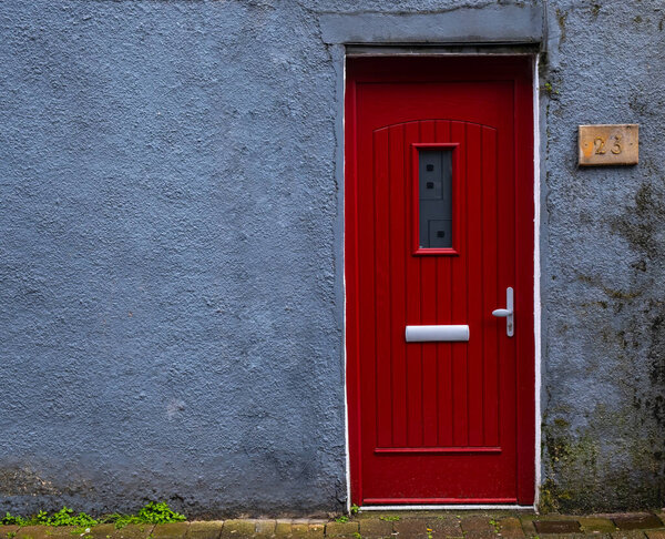 Traditional british house facade front entrance with red closed door. Traditional houses