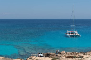 Turist yatı, yaz tatilinin tadını çıkaran turistlerle denizde geziyor. Yaz tatilleri. Cape Grego Ayia Napa Kıbrıs