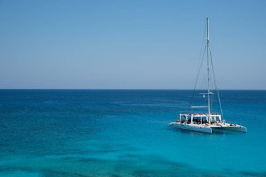 Turist yatı, yaz tatilinin tadını çıkaran turistlerle denizde geziyor. Yaz tatilleri. Cape Grego Ayia Napa Kıbrıs