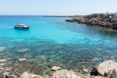 Turist yatı, yaz tatilinin tadını çıkaran turistlerle denizde geziyor. Yaz tatilleri. Cape Grego Ayia Napa Kıbrıs