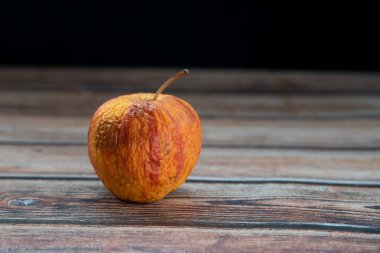 Masadaki kırmızı solmuş çürük elma. Çürük meyveleri enfekte eden bakteri.