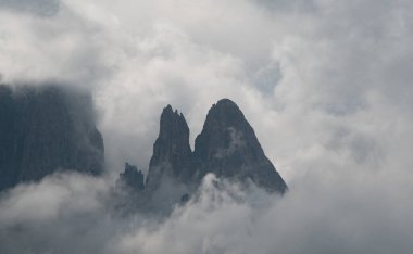 Güneşin doğuşunda mavi gökyüzüyle sisli kayalık dağ manzarası. İtalya 'daki Passo Sella Güney Tyrol' daki Dolomitlerin.