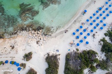 Plaj şemsiyeleri ve insanların yüzüp dinlendiği tropikal kumsal tatil beldelerinin insansız hava aracı antenleri. Yaz tatilleri. Landa plajı Ayia Napa Kıbrıs