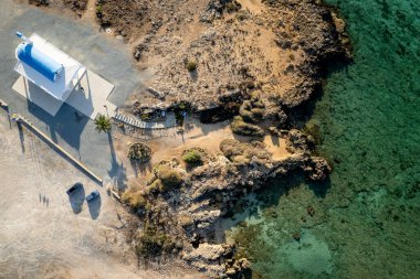 Beyaz Hıristiyan şapeli olan insansız hava aracı kayalık kıyı şeridi. Turkuaz suyla deniz manzaralı. Ayia thekla Kilisesi Ayia Napa Kıbrıs