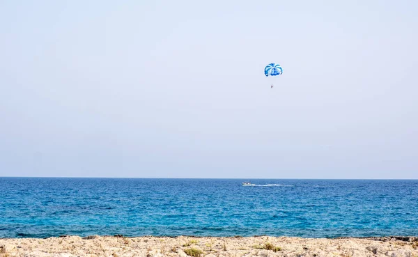 Turistler denizde paraşütle atlıyor. Yaz eğlencesi tatilleri, ekstrem sporlar. Ayia Napa situ